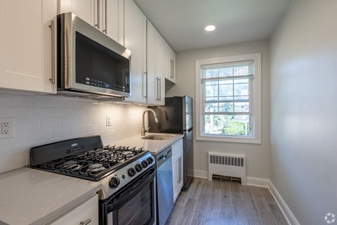 an empty kitchen with a stove and a microwave