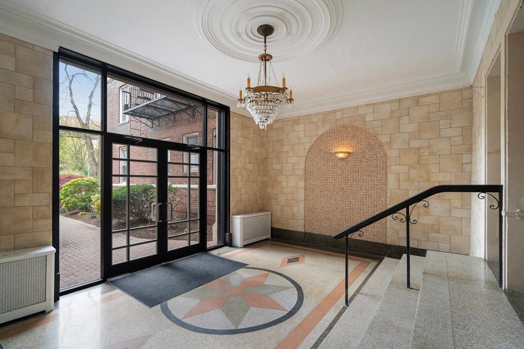 the lobby of a building with glass doors and a chandelier