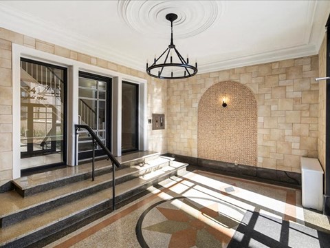 A foyer with a staircase and a chandelier.