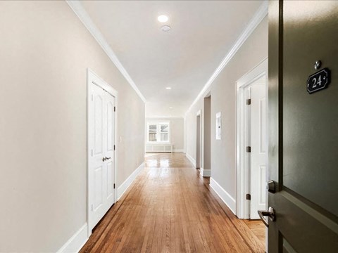 A long hallway with doors on both sides and a number 24 on the wall.