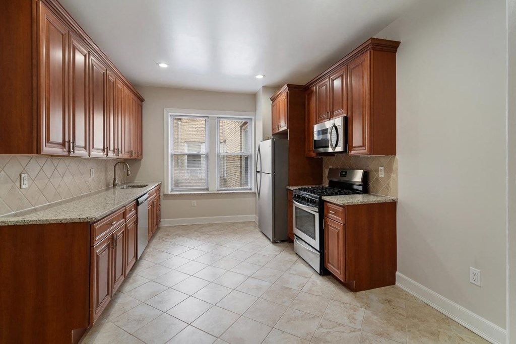 a kitchen with wooden cabinets and stainless steel appliances
