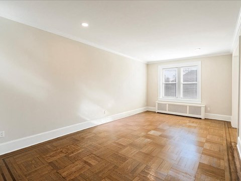 A room with wooden flooring and a window.