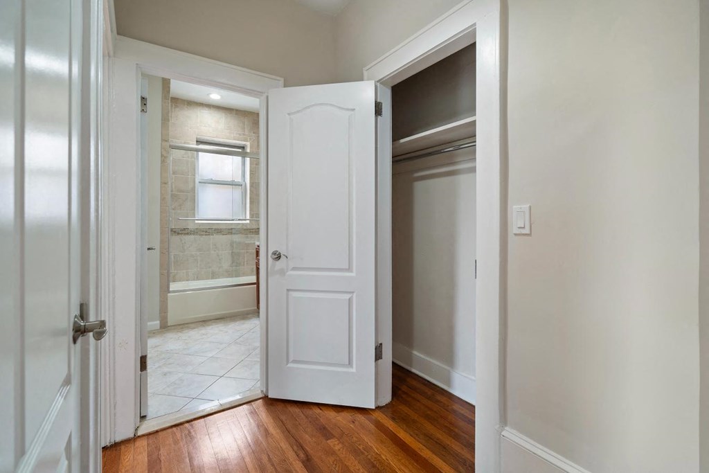 a bedroom with a door open to a bathroom and a closet