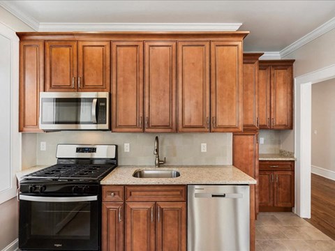 A kitchen with wooden cabinets and a black stove top oven.