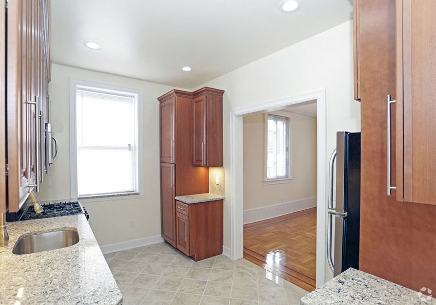a kitchen with wood cabinets and a sink and a refrigerator