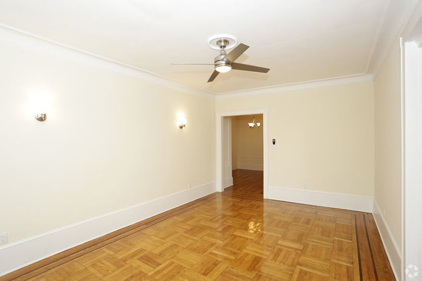 a living room with a ceiling fan and a wood floor