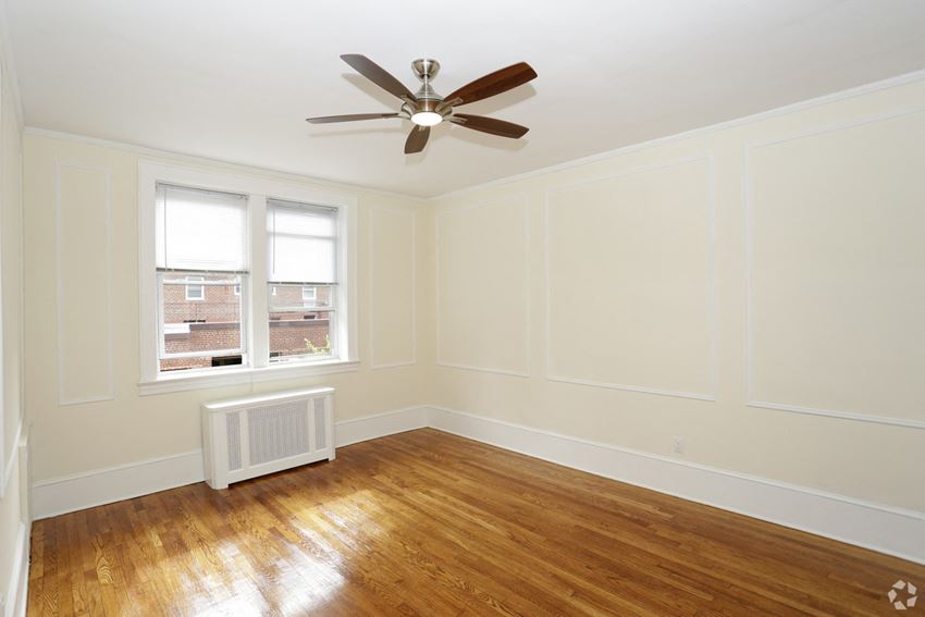 an empty room with a ceiling fan and a window