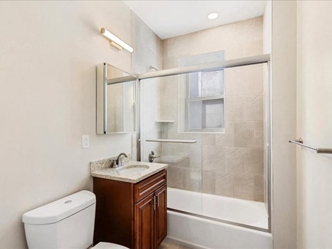 A bathroom with a toilet, sink, and shower.