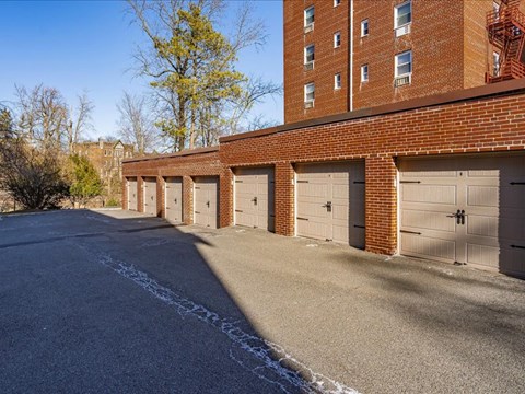 A long row of garage doors are lined up on a street.