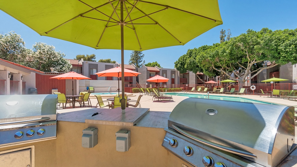 a backyard with a grill and a pool with umbrellas at Spring Meadow Apartments, Glendale, 85302