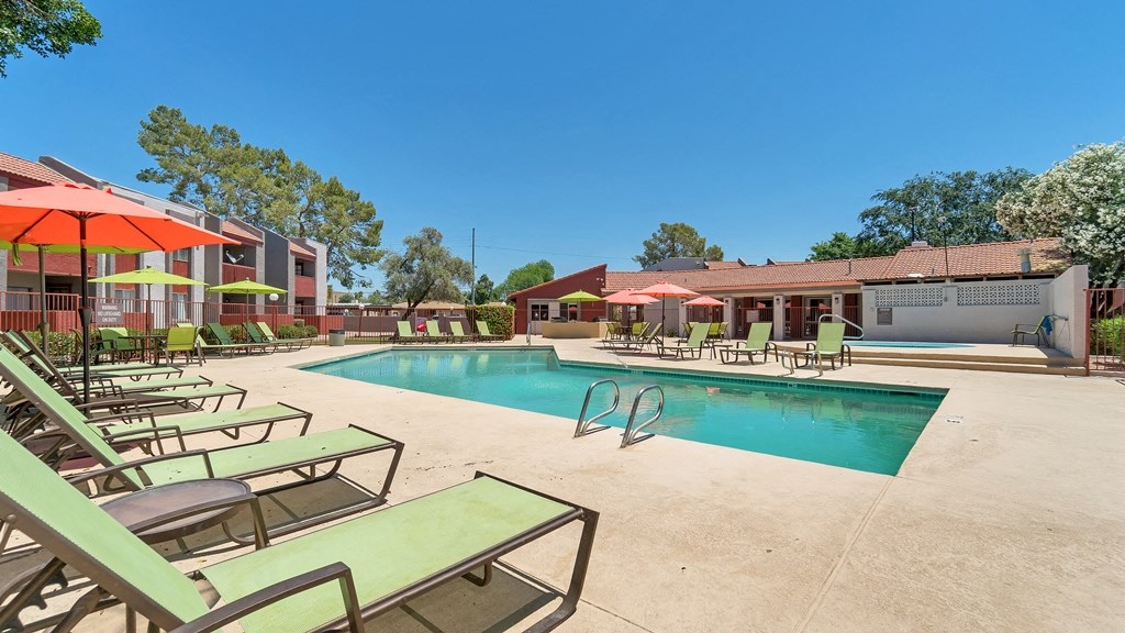 our apartments have a resort style pool with chairs and umbrellas at Spring Meadow Apartments, Arizona