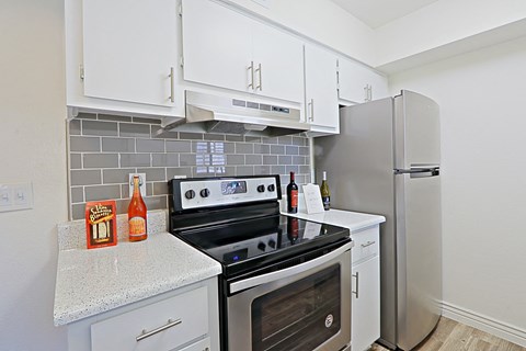 a kitchen with stainless steel appliances and white cabinets