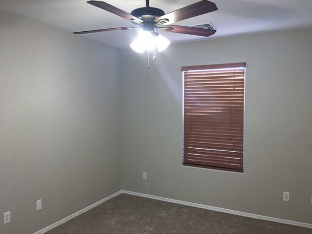 a room with a ceiling fan and a window