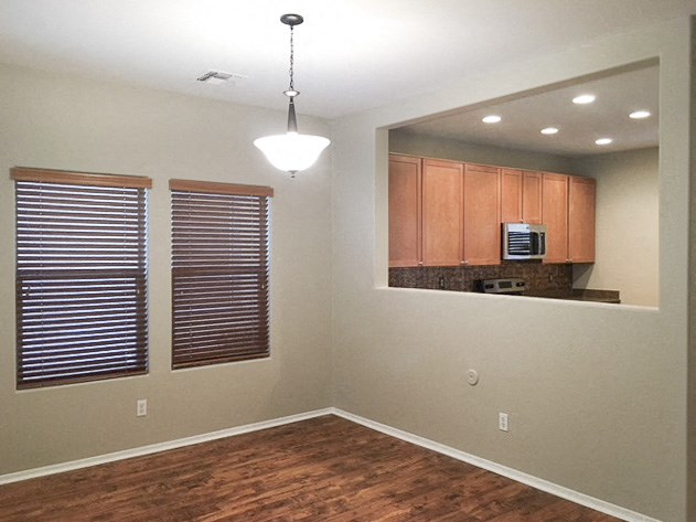 an empty room with a kitchen and a window