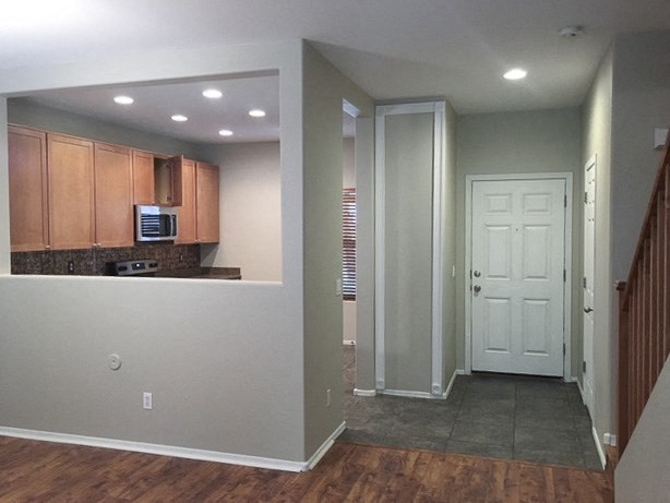 an empty room with a kitchen and a door