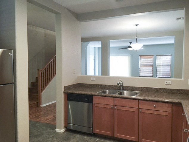 an empty kitchen with a sink and a refrigerator