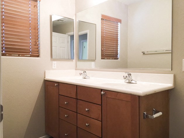 a bathroom with a sink and two mirrors