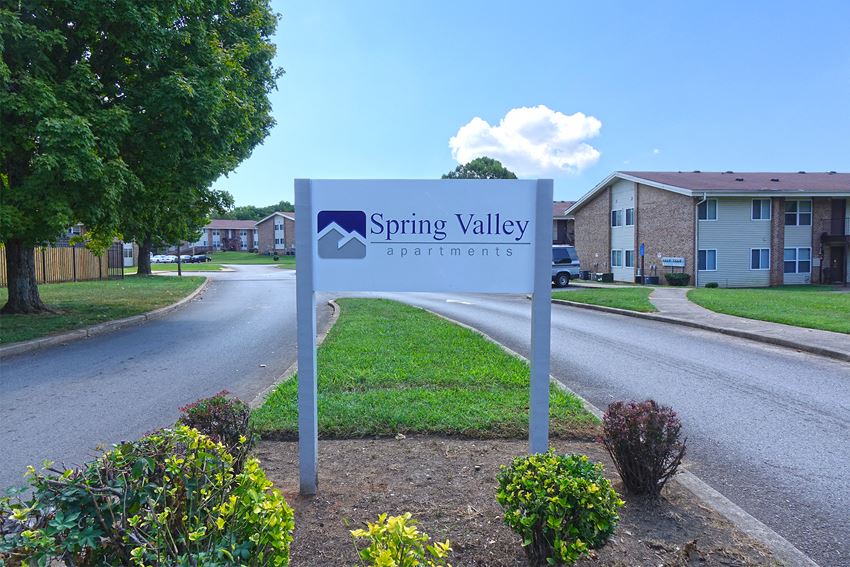 a sign that reads spring valley apartments on the side of a road