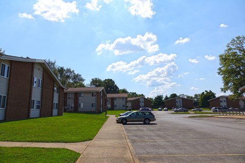 a car parked in a parking lot in front of apartment buildings