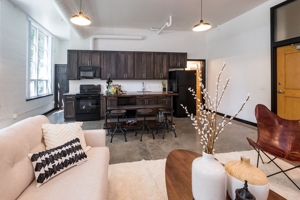 a living room and kitchen with a couch and a table