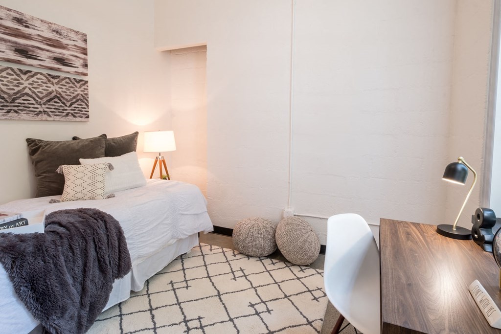 a bedroom with a bed and a desk with a chair