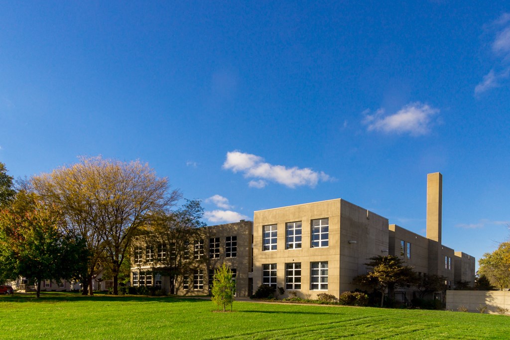 a building with a blue sky and a green field