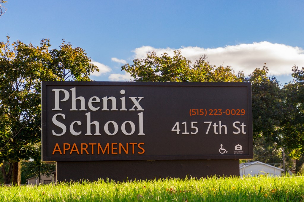 a sign for phoenix school on the side of a field