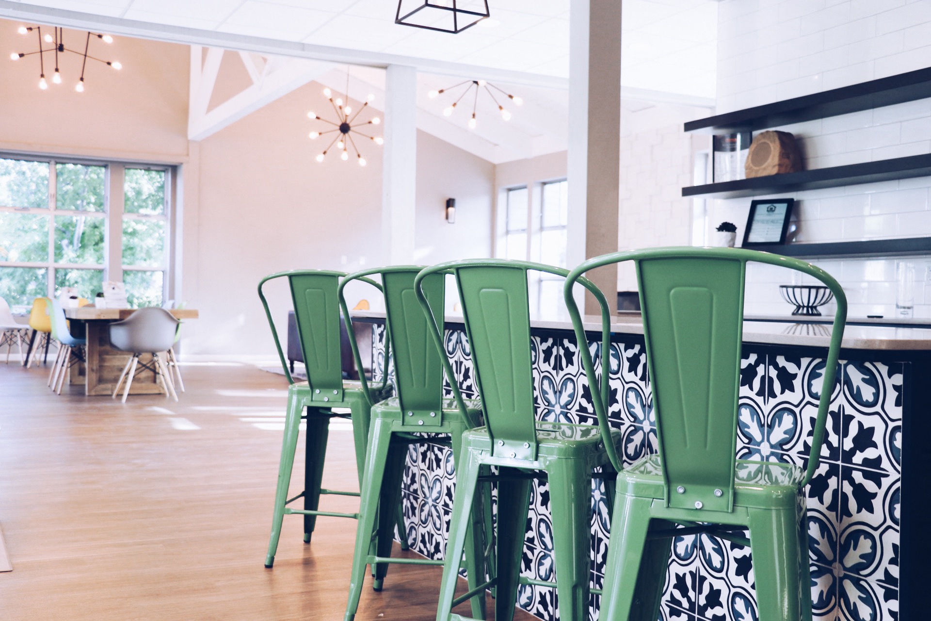 a dining room with green bar stools and a kitchen with a table and chairs