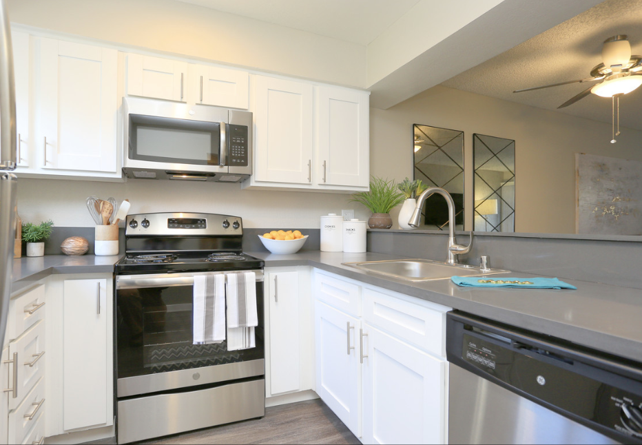 A modern kitchen with white cabinets and stainless steel appliances.