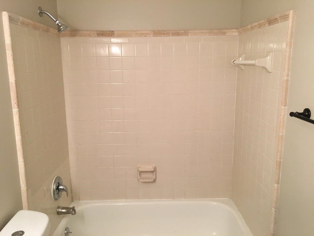 a white bathroom with a tub and a toilet