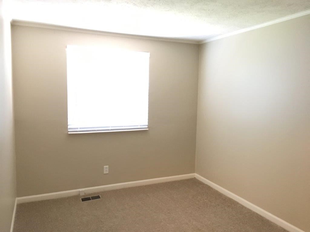 a empty room with a window and a carpet