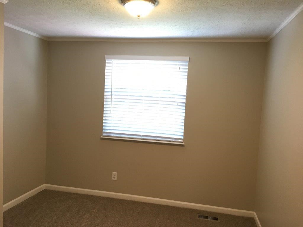 a bedroom with a window and a light on the ceiling