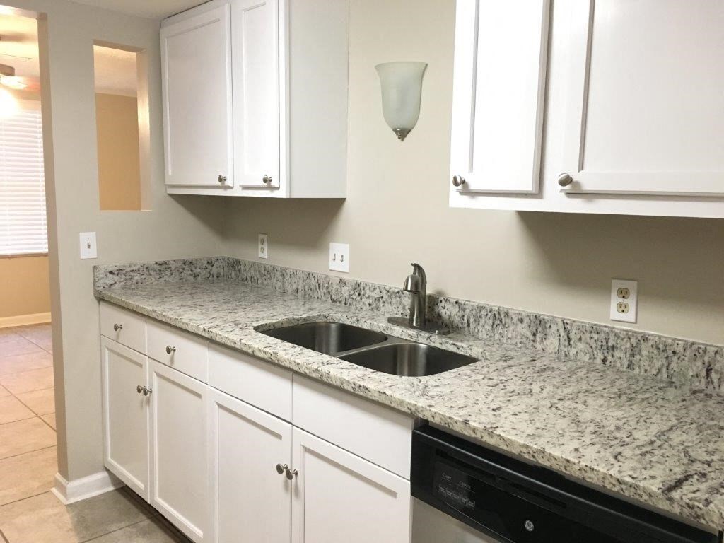 a kitchen with marble counter tops and a sink