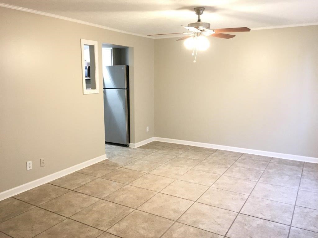 a empty room with a refrigerator and a ceiling fan