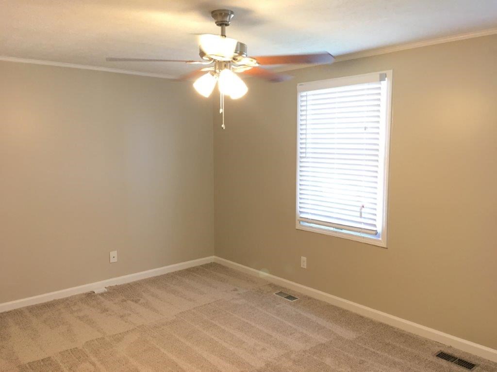 a empty room with a ceiling fan and a window