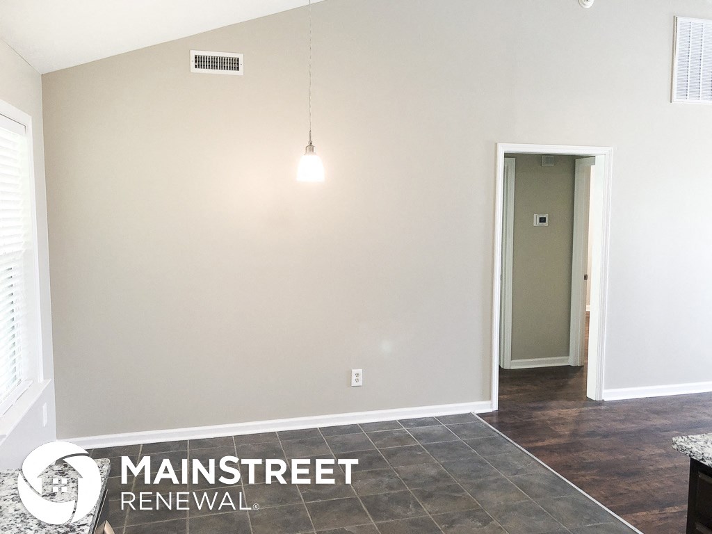 an empty room with a hallway and a door to a closet