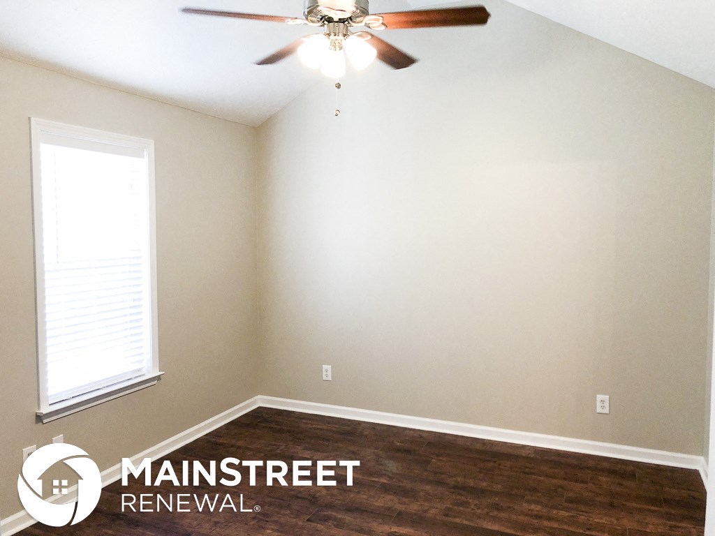an empty room with a ceiling fan and a window