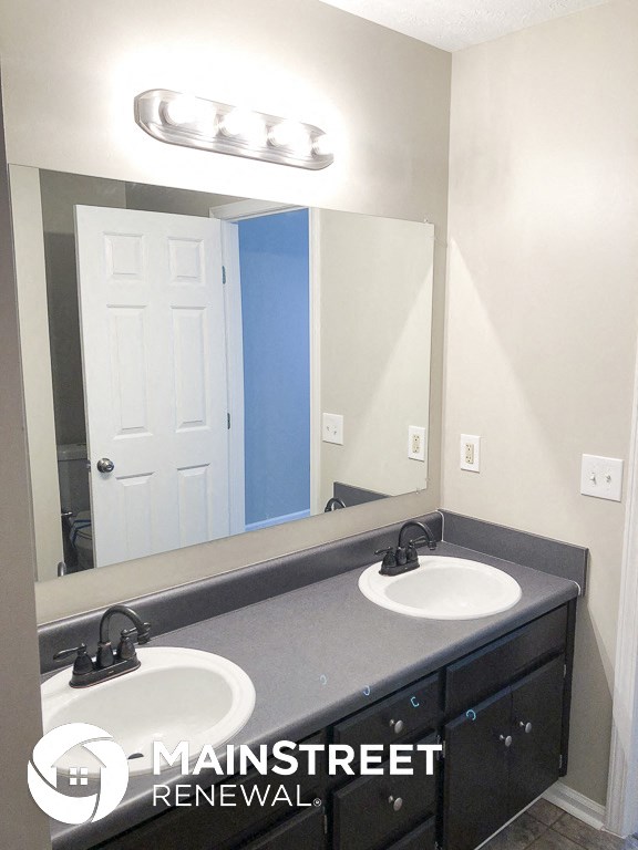 a bathroom with two sinks and a large mirror
