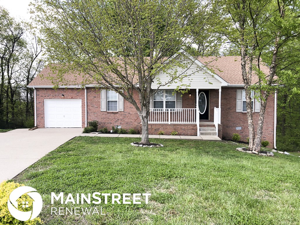 a home with a lawn and trees in front of it