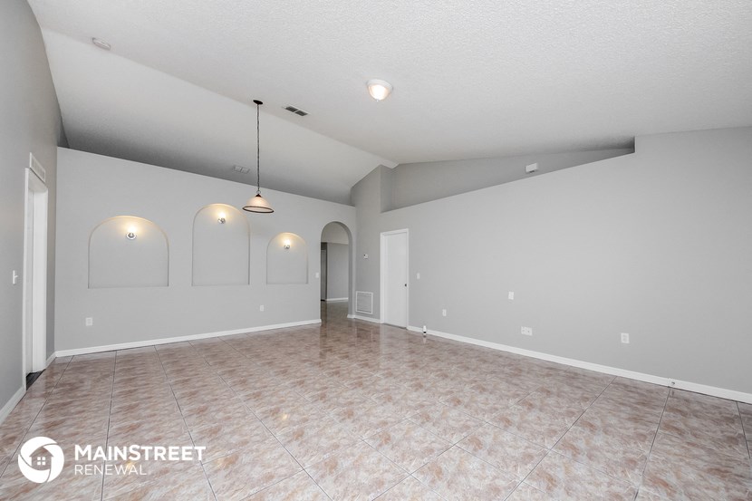 the spacious living room with tile flooring and grey walls