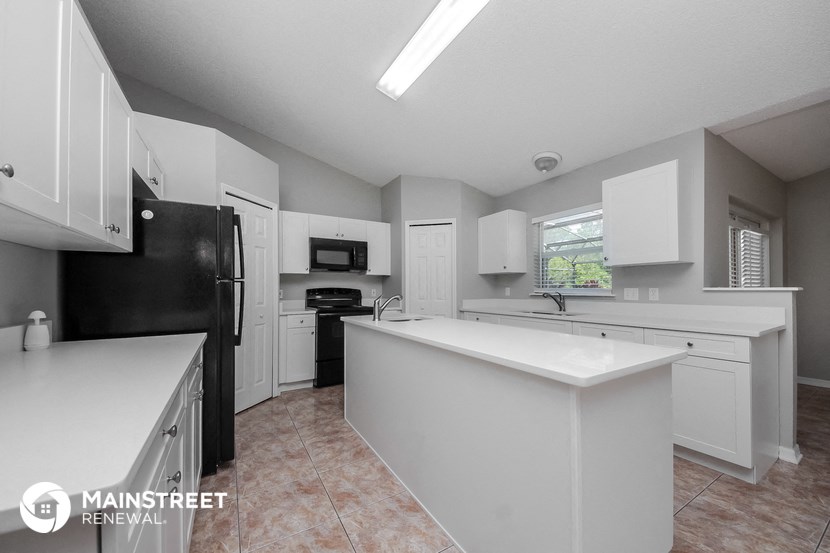 a large kitchen with white cabinets and black appliances