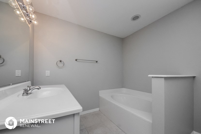 a white bathroom with a white sink and a tub and a toilet