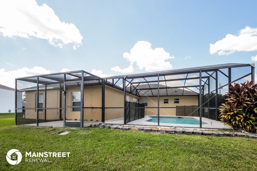 a house with a pool in the middle of a field