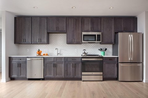 a kitchen with stainless steel appliances and dark wood cabinets