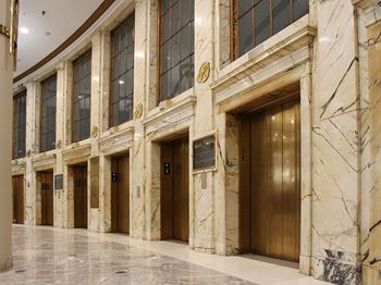Expansive restored lobby with exquisite marble floors and elevator facade, fountain and gold leaf details at Residences at Halle, Cleveland, OH, 44113