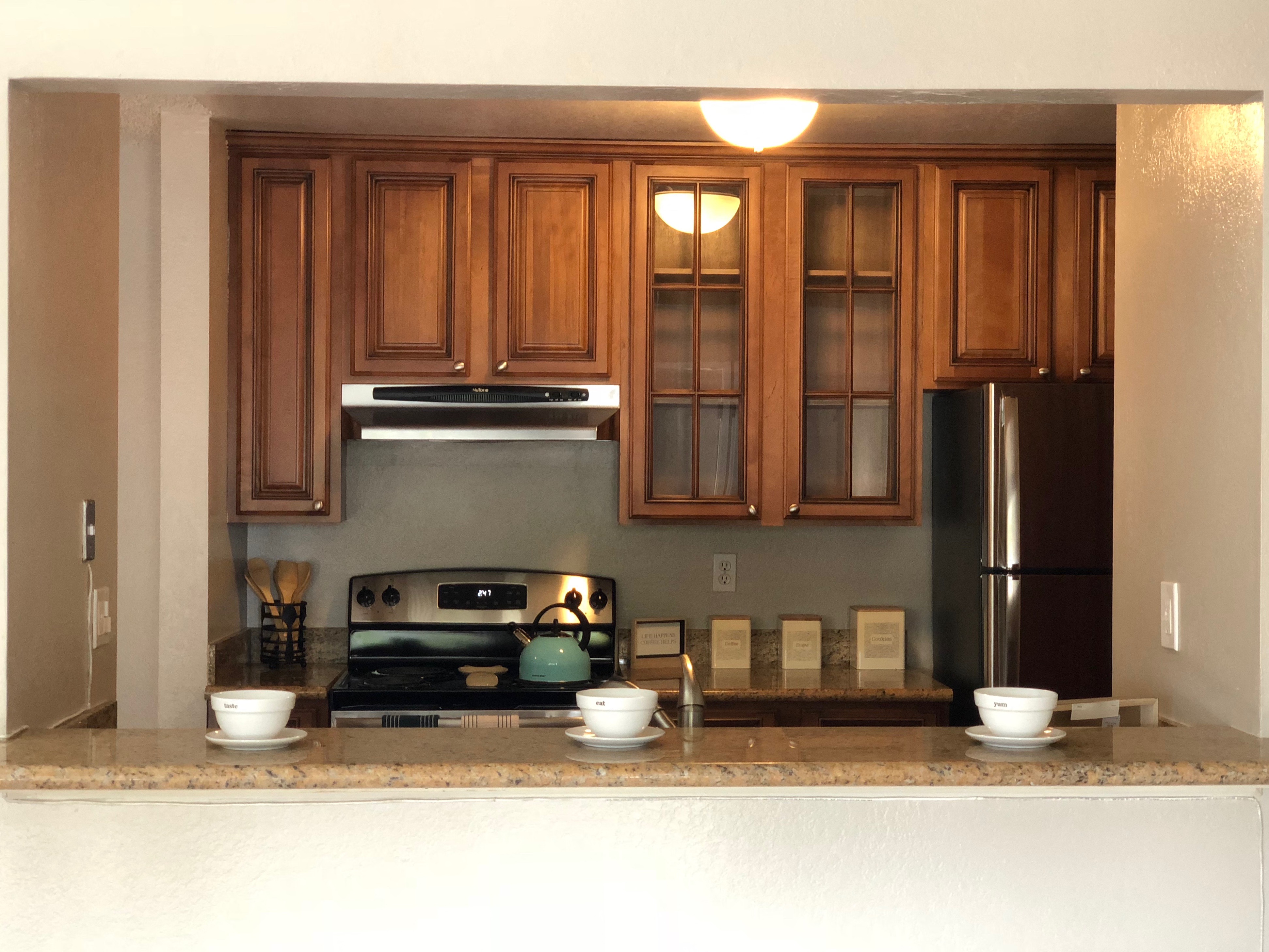 a kitchen with wooden cabinets and a stove and a refrigerator