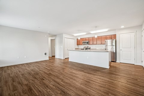 A kitchen with white cabinets and a wooden floor.