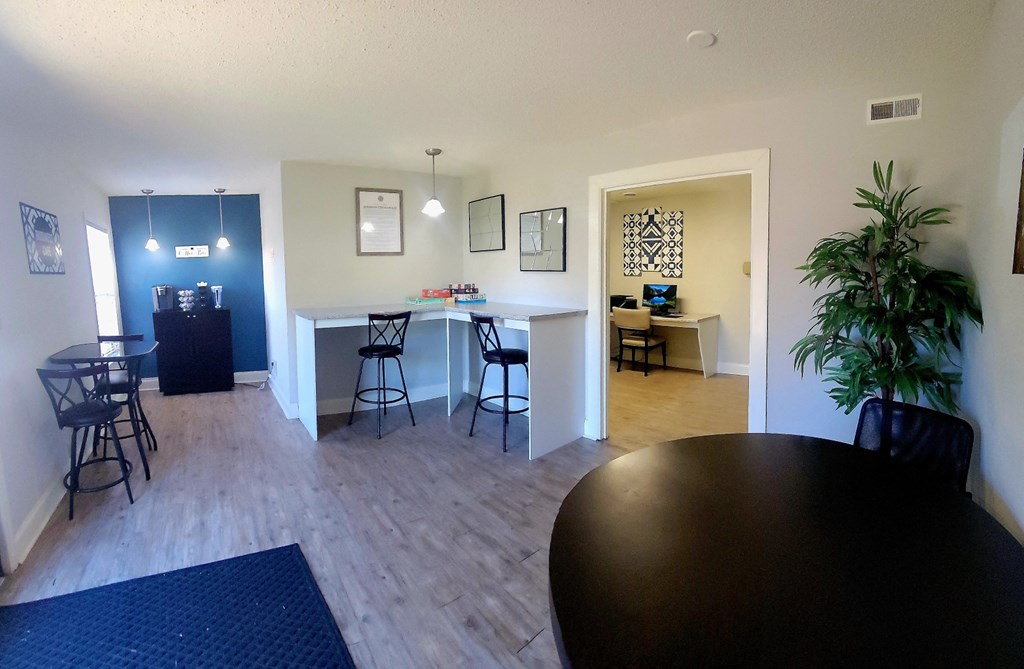 an open living room and kitchen with a dining room table and chairs and a bar