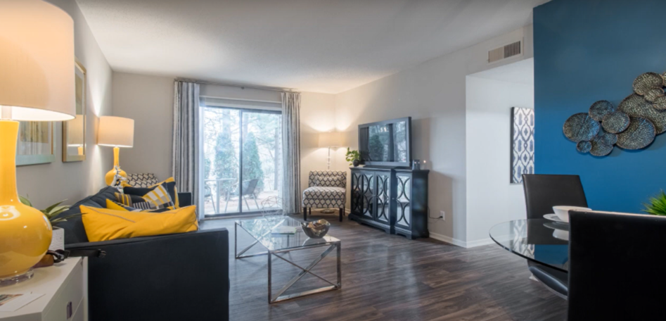 a living room with a blue accent wall and a sliding glass door