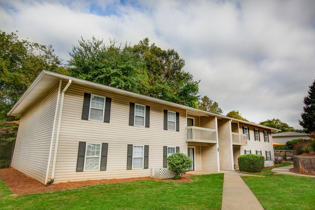 a white house with a sidewalk in front of a green yard
